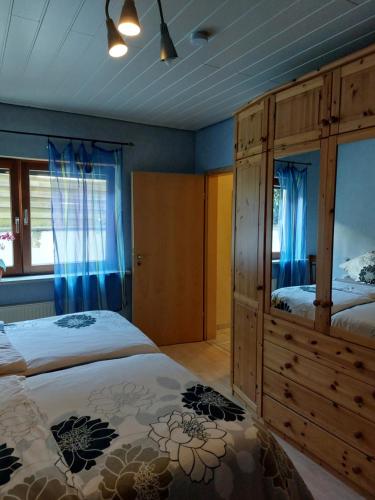 a bedroom with two beds and a wooden cabinet at Ferienwohnung am Stiefel in Sankt Ingbert