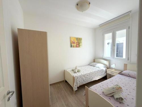 a small bedroom with two beds and a window at Ca' Luci in Marina San Gregorio