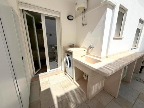a bathroom with a sink and a washing machine at Ca' Luci in Marina San Gregorio