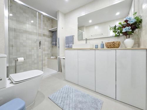 a white bathroom with a toilet and a sink at Apartment Praia Rocha River-Sea in Portimão
