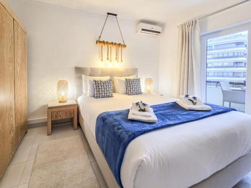 a bedroom with a large bed with two towels on it at Apartment Praia Rocha River-Sea in Portimão