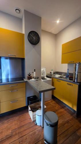 a kitchen with yellow cabinets and a table in it at T1 duplex centre Argeles Gazost in Argelès-Gazost