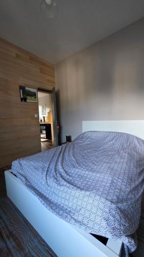 a bedroom with a bed with a blue blanket on it at T1 duplex centre Argeles Gazost in Argelès-Gazost