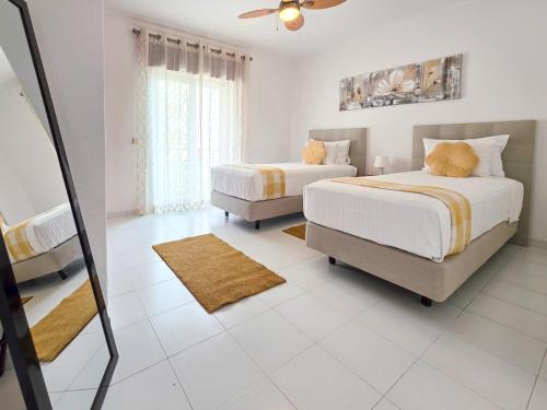 a bedroom with two beds and a mirror at Apartment Praia Rocha Candimar Sunflower in Portimão