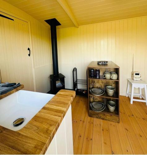 a kitchen with a stove in a room at Coorie and Keek Shepherd's Hut in Prestrie