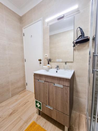 a bathroom with a sink and a mirror at Apartment Praia Rocha Candimar Sunflower in Portimão