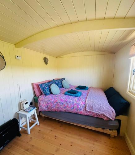 a bedroom with a bed in a room at Coorie and Keek Shepherd's Hut in Prestrie