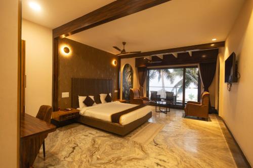 a bedroom with a king sized bed and a desk at Nautical 9 Beach Retreat in Kundapur