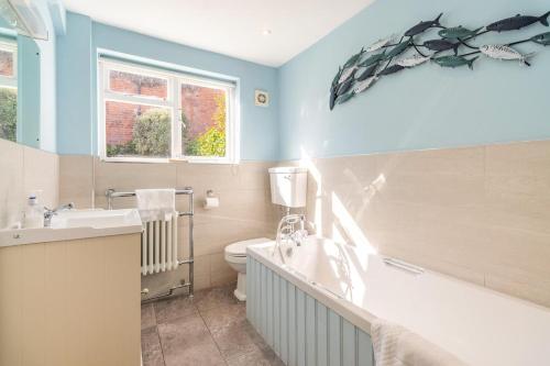 a bathroom with a sink and a toilet and a tub at 3 Bed in Southwold oc-hsmugg in Southwold