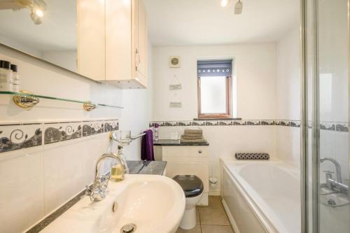a bathroom with a sink and a tub and a toilet at 3 Bed in Little Ellingham oc-2147 in Rockland Saint Peter