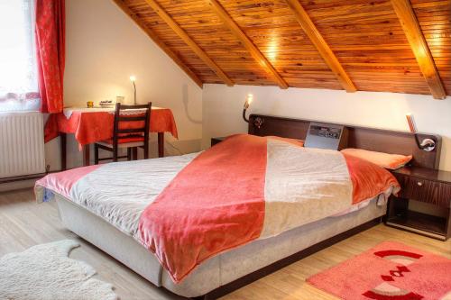 a bedroom with a bed and a desk and a table at location Chambre Privée à La Ferme Maryla in Ratkovica
