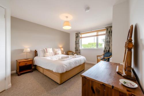 a bedroom with a bed and a desk and a window at 2 Bed in Putsborough oc-flat31 in Croyde