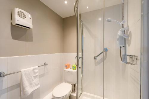 a bathroom with a toilet and a glass shower at 2 Bed in Putsborough oc-flat31 in Croyde