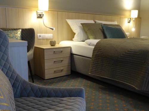 a hotel room with a bed and a chair at Das LENNI in Büren