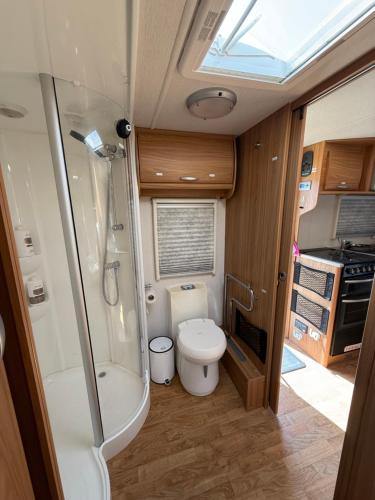 a small bathroom with a toilet and a shower at Little Hideaway Deluxe in Costa da Caparica