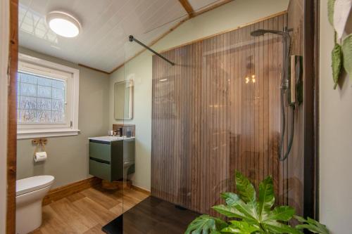 a bathroom with a shower and a toilet at Appin Holiday Homes - Lodges, Shepherds Hut and Train Carriage stays in Appin