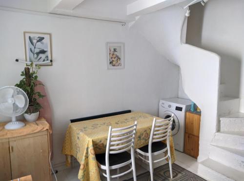 a dining room with a table and two chairs at Tiny House 1, 2 ou 3 personnes SoeursGrises Béziers Centre Historique coeur de l'Hérault Occitanie, plus vieille ville de France, chemin de Compostelle à pied ou velo, passeport du pèlerin 24h, petits dejeuners et repas, 300m du centre ville in Béziers