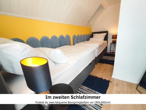 a room with two beds and a yellow wall at GlanzExperts Auszeit bei Berlin Balkon Kicker & DisneyPlus in Zossen