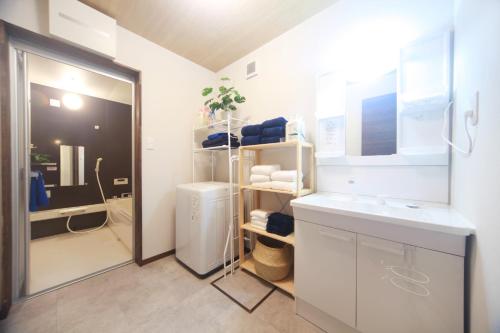 a white bathroom with a sink and a refrigerator at TOMOSHIBI Kurashiki Zen House Near Bikan Historical Quarter 美観地区近く 和モダン一棟貸し in Kurashiki
