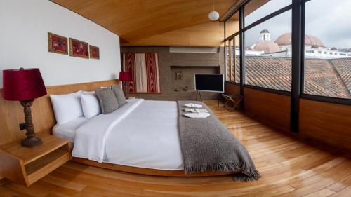 a bedroom with a large bed and a large window at Casa Santa Clara - Colonial Boutique Hotel in Quito