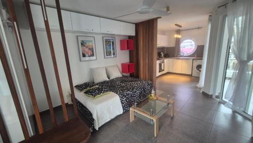 a small bedroom with a bed and a kitchen at ONLY4VIEW Beach Front in Sainte-Anne