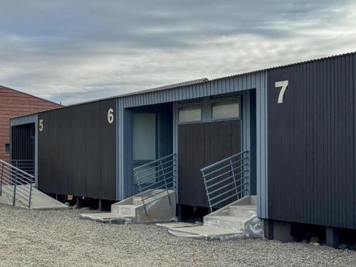 a black building with stairs and a building with the number seven at Simple Aparts in El Calafate