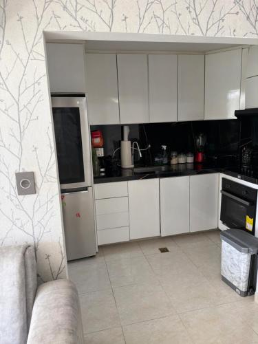 eine Küche mit weißen Schränken und einem Sofa in der Unterkunft Manhattan PH in Cúcuta