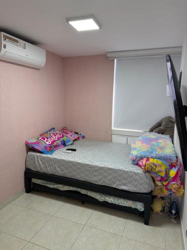 ein kleines Bett in einem Zimmer mit Fenster in der Unterkunft Manhattan PH in Cúcuta
