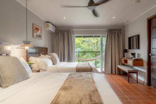 a bedroom with two beds and a window at Hotel Alto Monte Hacienda & Spa - Only Adults in Chiguirí Arriba