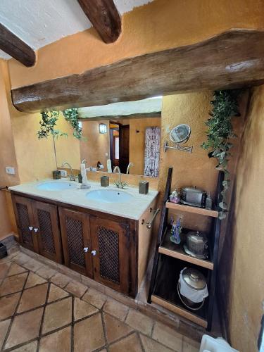 ein Badezimmer mit Waschbecken und großem Spiegel in der Unterkunft Mas Valoria in Peratallada
