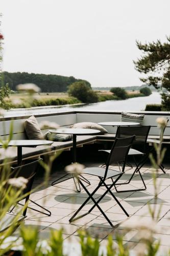a patio with a table and chairs on a balcony at Mooirivier in Dalfsen