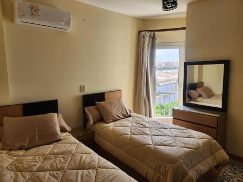 a hotel room with two beds and a window at Modern 3-BR gated Sheikh Zayed Compound Open Views in Sheikh Zayed