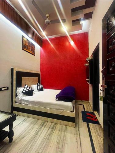 a bedroom with a bed with a red wall at HOTEL Gumber in Sirsa