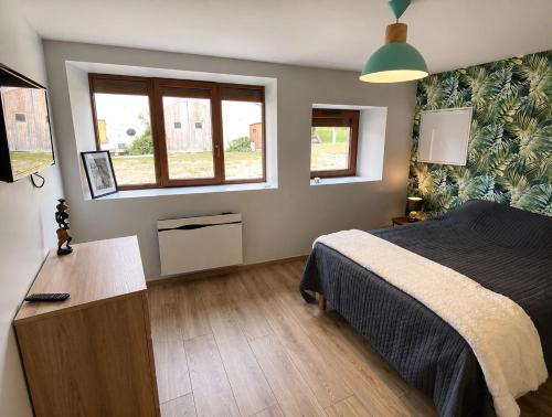 a bedroom with a bed and a desk and a window at LE GITE DU LYNX N°2 in Cernon