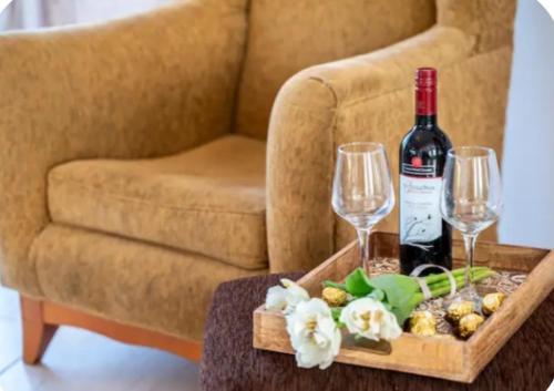 a table with a bottle of wine and two glasses at Aegean Whispers House in Psalidi