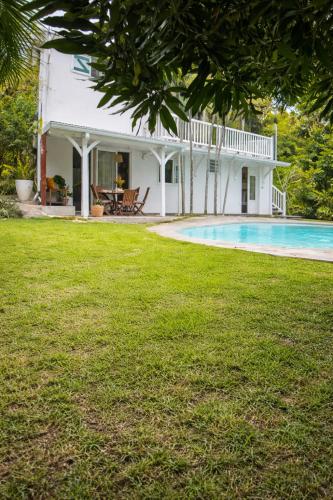 a house with a swimming pool in the yard at Lagon privé du Diamant in Le Diamant