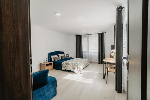 a bedroom with a bed and a table with a chair at WhiteBergHaus Colibita in Colibiţa