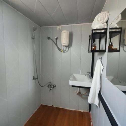 a bathroom with a shower and a sink at OrchardNest in Moinabad