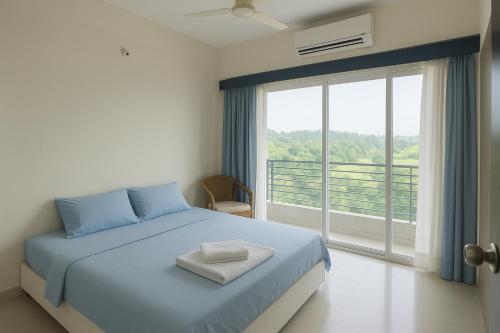 a bedroom with a bed and a large window at Epindi Studio Apartment in Cox's Bazar