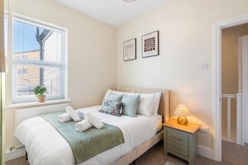 a bedroom with a white bed with a window at Spacious 2-Bed Eastbourne Retreat in Eastbourne