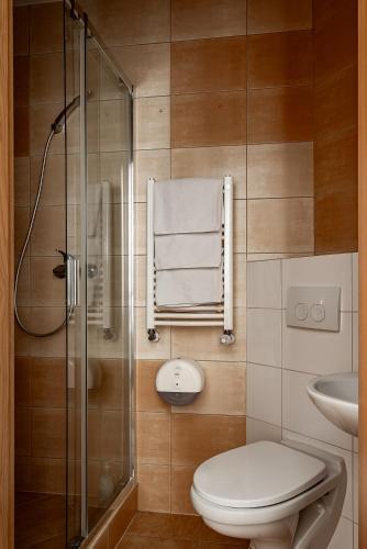 a bathroom with a toilet and a glass shower at Restauracja Sonata in Zwierzyniec
