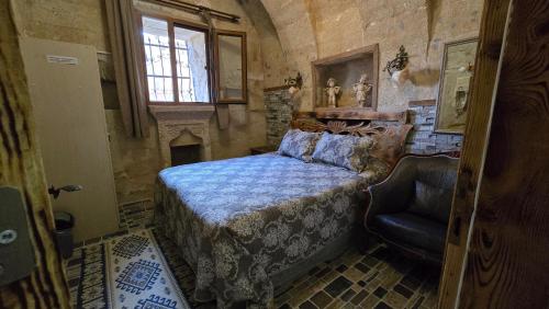 a bedroom with a bed and a chair in a room at Uchisar Cave House in Uçhisar