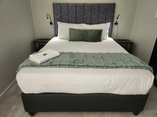 a bedroom with a large bed with a gray headboard at GQ Short Stays at Bellamare in Summerstrand