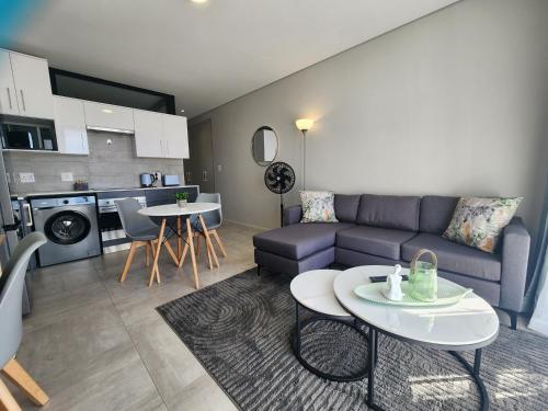 a living room with a couch and a table at GQ Short Stays at Bellamare in Summerstrand