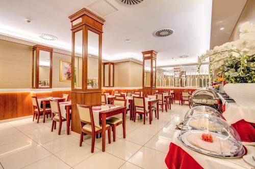 a restaurant with tables and chairs in a room at Augusta Lucilla Palace in Rome