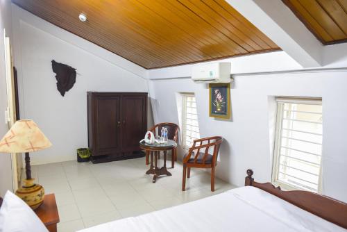 a bedroom with a bed and a table and chairs at Maison Vy Homestay in Hue
