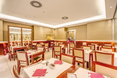 a restaurant with tables and chairs in a room at Augusta Lucilla Palace in Rome