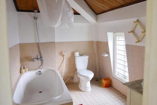 a bathroom with a toilet and a bath tub at Maison Vy Homestay in Hue