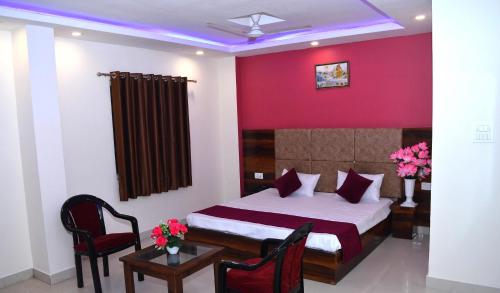a bedroom with a bed and a table and chairs at Hotel Exotica Haridwar in Rāiwāla