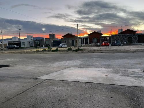 an empty street with houses and a sunset in the background at Entre Montañas in Rivadavia